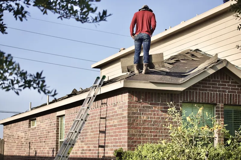 Professional roofer working on a residential roof in Liberty
